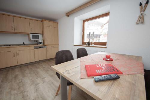 a kitchen with a table with a book on it at Rimls Landhaus in Sölden