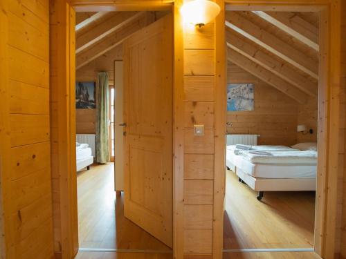um quarto com duas camas numa casa de madeira em Horská chata KorAlpe em Hartelsberg