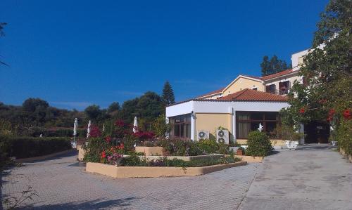 a building with flowers and plants in front of it at Karavados Beach Hotel in Karavadhos