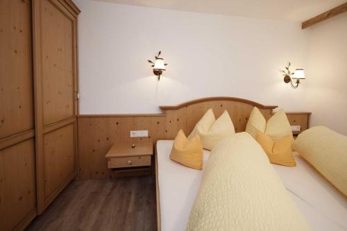 a bedroom with two beds with yellow pillows at Rimls Landhaus in Sölden