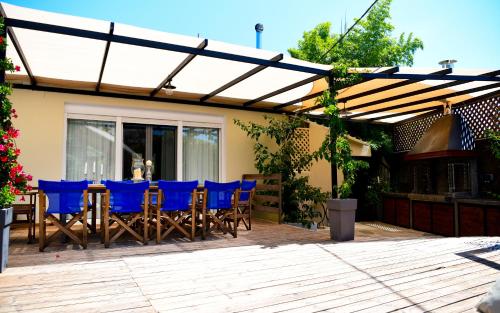 a patio with blue chairs under a pergola at Serenity Luxury Villa, Skiathos in Agia Paraskevi