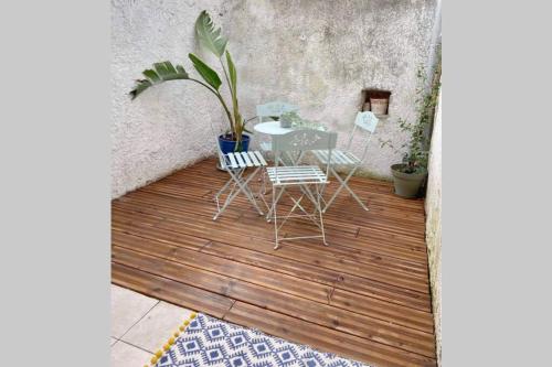 un patio con tavolo e sedie su un pavimento in legno di Superbe appartement en pierre fraîchement rénové a Bernis