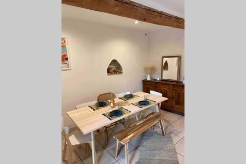 uma sala de jantar com mesa e cadeiras em Superbe appartement en pierre fraîchement rénové em Bernis