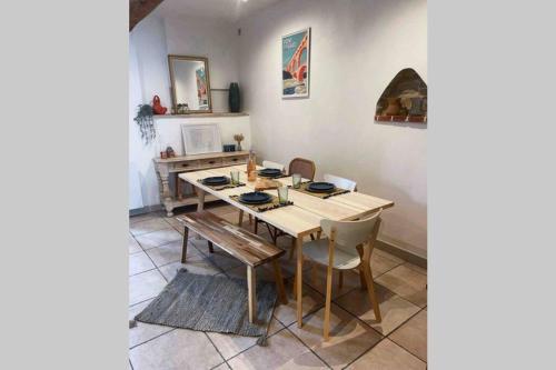 a dining room with a wooden table and chairs at Superbe appartement en pierre fraîchement rénové in Bernis