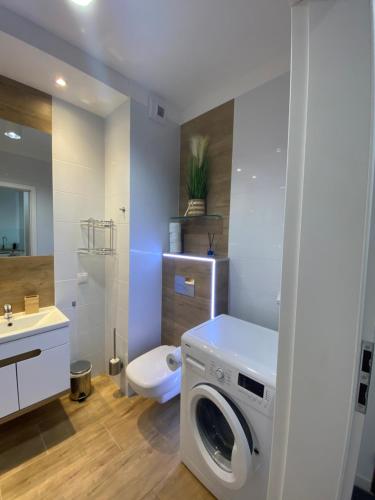 La salle de bains est pourvue d'un lave-linge et de toilettes. dans l'établissement Maya's Flats & Resorts 39 - Walowa 25D, à Gdańsk