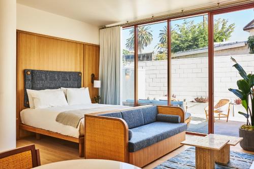 een slaapkamer met een bed en een bank bij Alsace LA in Los Angeles