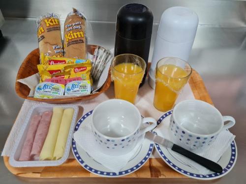 a tray of food with two cups and some drinks at PENSEENTRE MOTEL in Rio Claro