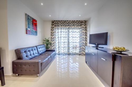 a living room with a couch and a television at Apartamentos 7 Saias Marginal in Nazaré
