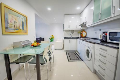 a kitchen with a table and a microwave at Apartamentos 7 Saias Marginal in Nazaré