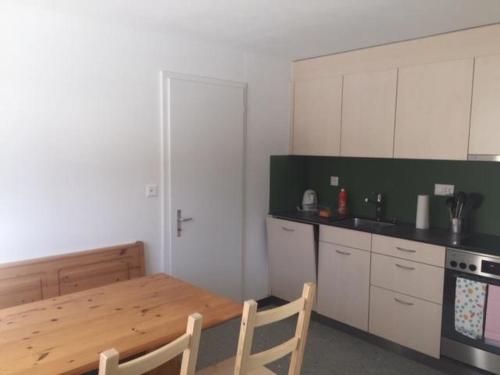 una cucina con tavolo in legno e una cucina con piano cottura di Apartment Lucie by Interhome ad Adelboden