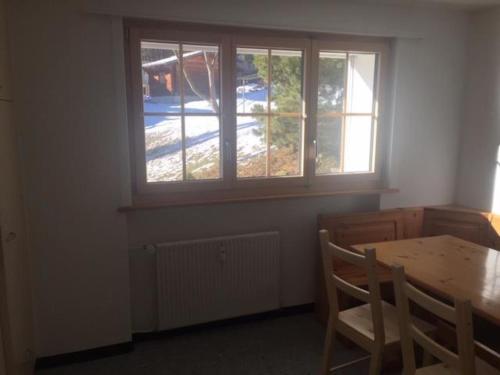 uma sala de jantar com uma mesa e uma janela em Apartment Lucie by Interhome em Adelboden