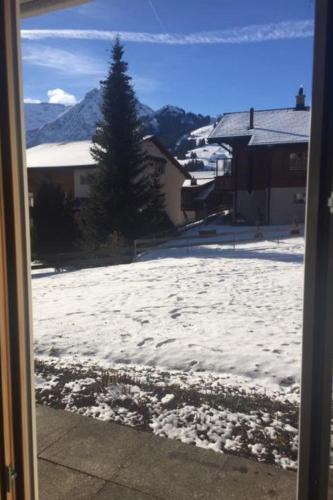 a view of a snow covered yard through a window at Apartment Lucie by Interhome in Adelboden