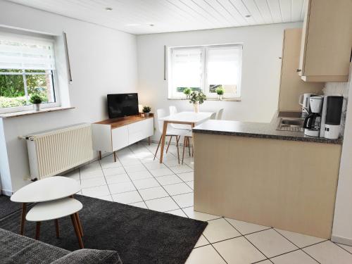 eine Küche und ein Wohnzimmer mit einem Tisch und Stühlen in der Unterkunft Ferienwohnung Waldblick Teutoburger Wald in Oerlinghausen