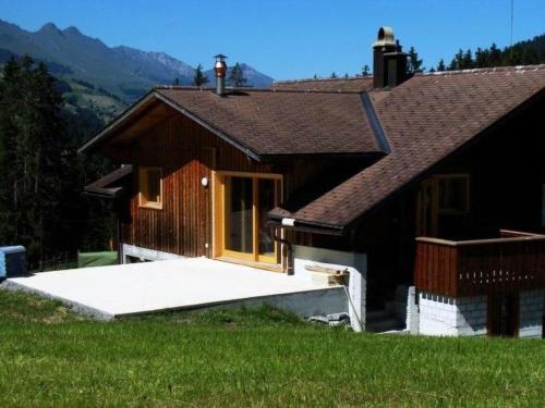 ein kleines Haus mit einer Veranda und einem Haus in der Unterkunft Apartment Burn- Alte Strasse by Interhome in Adelboden