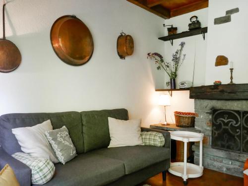 Holiday Home Chalet Al Portic by Interhome : غرفة معيشة مع أريكة خضراء ومدفأة