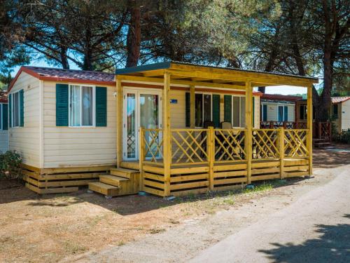 uma pequena casa com um alpendre e um deque em Holiday Home Brioni Sunny Camping by Interhome em Pula