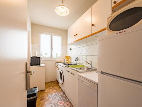 La cuisine est équipée d'un réfrigérateur blanc et d'un lave-vaisselle. dans l'établissement Apartment Evasion-2 by Interhome, à Cavalaire-sur-Mer