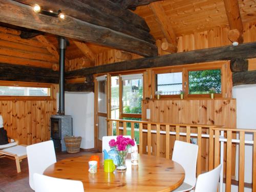 uma sala de jantar em madeira com uma mesa e cadeiras brancas em Holiday Home Rustico Enrico by Interhome em Campo Blenio