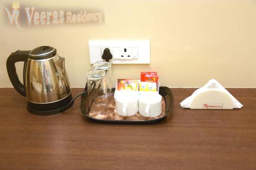a tray with candles and a tea kettle on a table at Veeras Residency in Puducherry