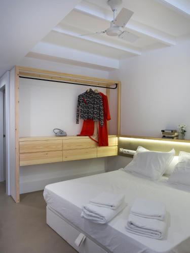 a bedroom with a bed and a shelf with towels at Best House Best Place in Barcelona