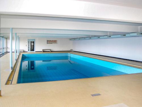 a swimming pool with blue water in a building at Apartment Derborence 28 by Interhome in Nendaz