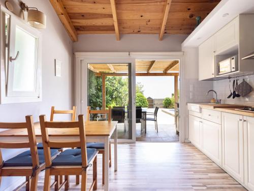 a kitchen with white cabinets and a wooden table and chairs at Holiday Home Jorge by Interhome in Zamorano