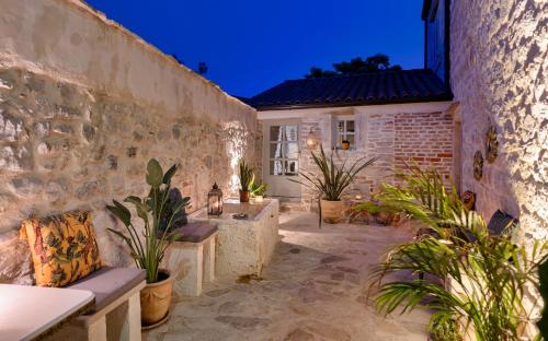 un patio extérieur avec des plantes en pot et un bâtiment dans l'établissement Town House Rosario, à Stari Grad