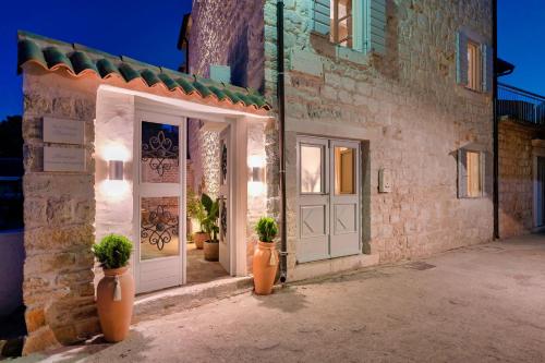 a building with two vases with plants in it at Town House Rosario in Stari Grad