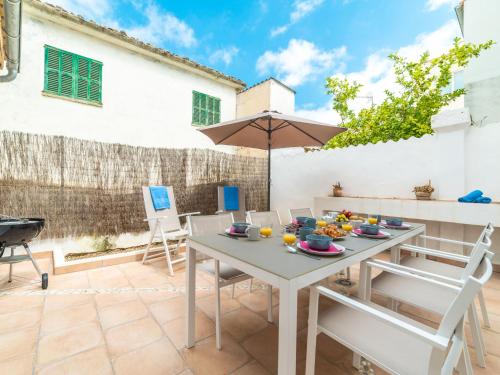 a patio with a table and chairs and an umbrella at Holiday Home Can Monjo by Interhome in SʼArrocó