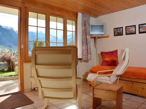 1 dormitorio con 1 cama, 1 silla y TV en Apartment Marielle by Interhome, en Adelboden