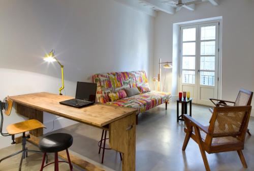 a living room with a table with a laptop on it at Best House Best Place in Barcelona