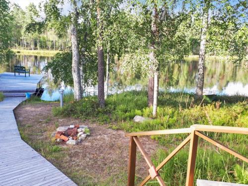 a fire pit next to a lake with a bench at Holiday Home Polkurinne by Interhome in Saarijärvi