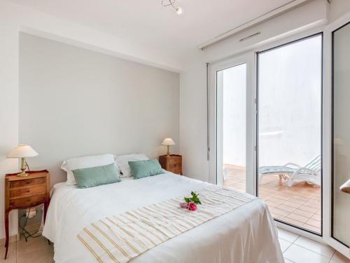 une chambre blanche avec un lit et un balcon dans l'établissement Holiday Home Armorique by Interhome, à Carnac