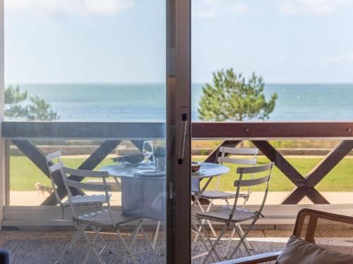 une table et des chaises sur un balcon avec vue sur l'océan dans l'établissement Studio Le Britannia-3 by Interhome, à Carnac