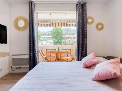 une chambre avec un grand lit avec des oreillers roses dans l'établissement Studio Les Aigues Marines-61 by Interhome, à Saint-Cyr-sur-Mer