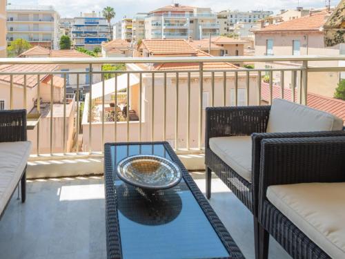 d'une terrasse avec 2 chaises et une table sur un balcon. dans l'établissement Apartment Presqu'Ile by Interhome, à Cannes