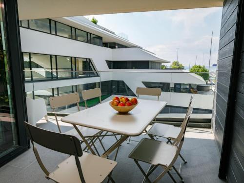 a table and chairs on a balcony with a bowl of fruit at Apartment Füred by Interhome in Balatonszemes