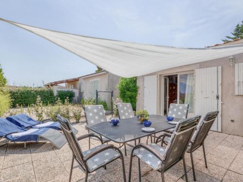 une terrasse avec une table et des chaises ainsi qu'une tente dans l'établissement Holiday Home Le Green Village-3 by Interhome, à Roquebrune-sur Argens