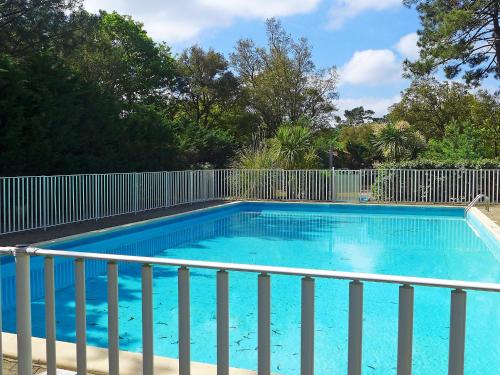 a large blue swimming pool next to a fence at Holiday Home Paradise Océan-13 by Interhome in Capbreton