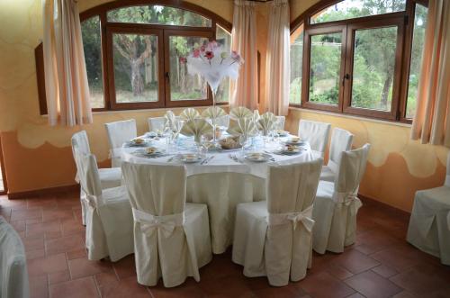 a dining room with a white table and chairs at Hotel Giardino Corte Rubja in Iglesias