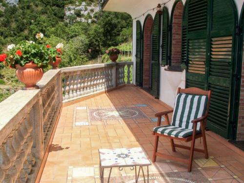 een patio met een stoel, een tafel en een vaas bij Holiday Home Path of the Gods by Interhome in Vettica Maggiore