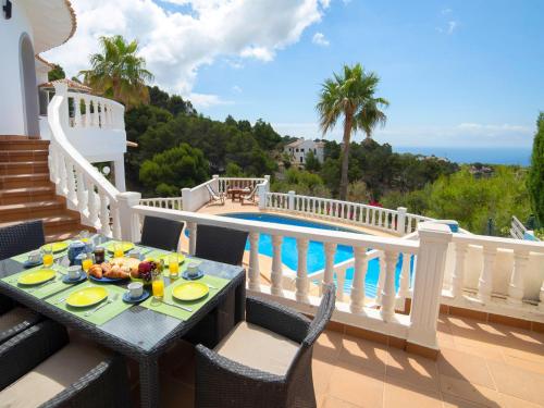 a table with food on a balcony with a view of a pool at Villa Mona Lisa by Interhome in Altea