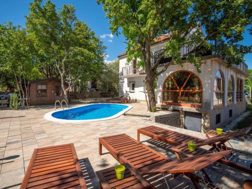 un patio con sillas de madera y una piscina en Holiday Home Noveanni by Interhome, en Kornić