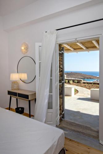 a bedroom with a bed and a view of the ocean at Horizon Villas in Agios Ioannis