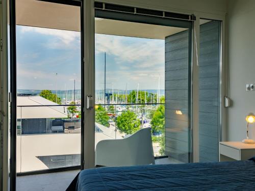 a bedroom with a bed and a view of a city at Apartment Fűzfő by Interhome in Balatonszemes