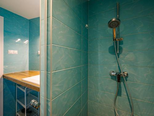 a bathroom with a shower with blue tiles at Apartment Fűzfő by Interhome in Balatonszemes