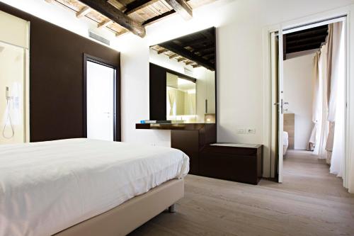 a bedroom with a white bed and a mirror at Borgoleoni 18 - Room and Breakfast in Ferrara
