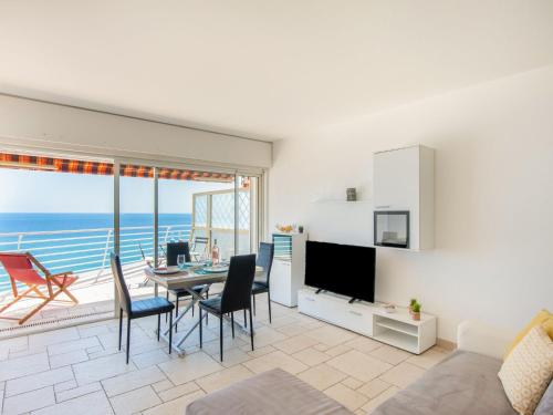 un salon avec une table et des chaises et l'océan dans l'établissement Apartment Le Chantilly 1 by Interhome, à Cagnes-sur-Mer