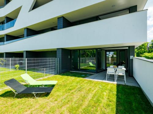 a backyard of a house with grass and a table and chairs at Apartment Földvár by Interhome in Balatonszemes