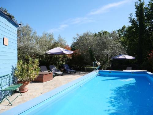 een zwembad met stoelen en parasols in een tuin bij Holiday Home Casa Poesia by Interhome in Boccheggiano
